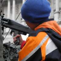 schenkt kindern kein kriegsspielzeug – lasst sie mit echten waffen spielen – 010 - kinder spielen mit kriegsgeraet und werden dabei von soldaten beraten.