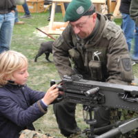 schenkt kindern kein kriegsspielzeug – lasst sie mit echten waffen spielen – 014 - kinder spielen mit kriegsgeraet und werden dabei von soldaten beraten.